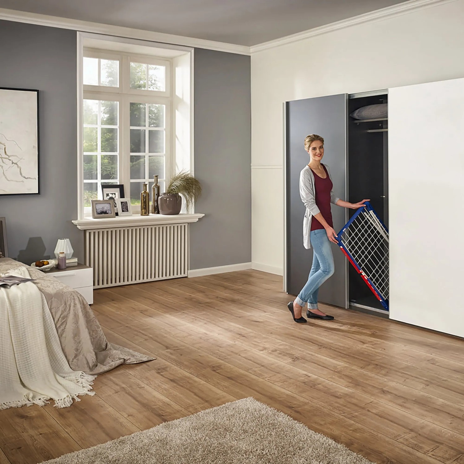 Frau verstaut Leifheit Wäscheständer Pegasus 150 Solid Slim im Schrank.