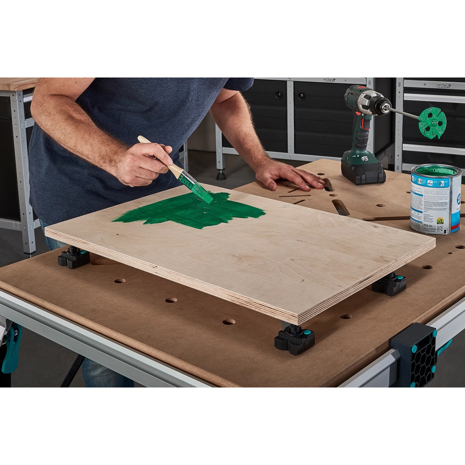 Wolfcraft Spannbacken-Set mit Lackierspitzen im Einsatz auf Werkbank beim Lackieren eines Holzstücks.