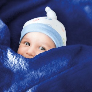 Baby unter blauer Bestlivings Mikrofaser Babydecke (60x80 cm) mit Mütze.