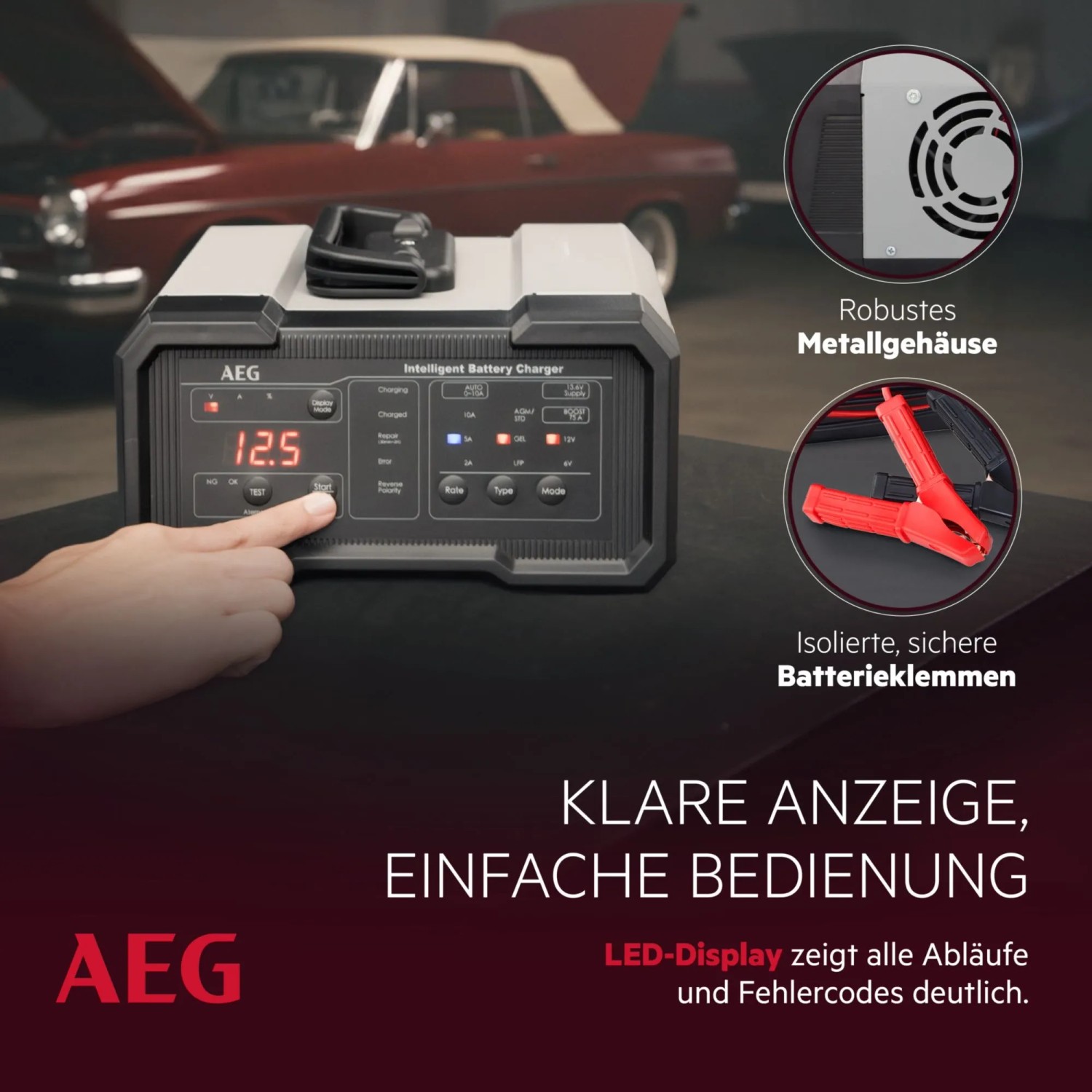 AEG Batterieladegerät CW10 mit LED-Display und Batterieklemmen vor Oldtimer. Autoelektrik Zubehör.
