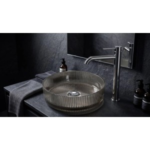 Rundes, geriffeltes Rauchglas Aufsatzwaschbecken auf dunkler Waschtischplatte mit hohem Chrom-Wasserhahn im modernen Bad.