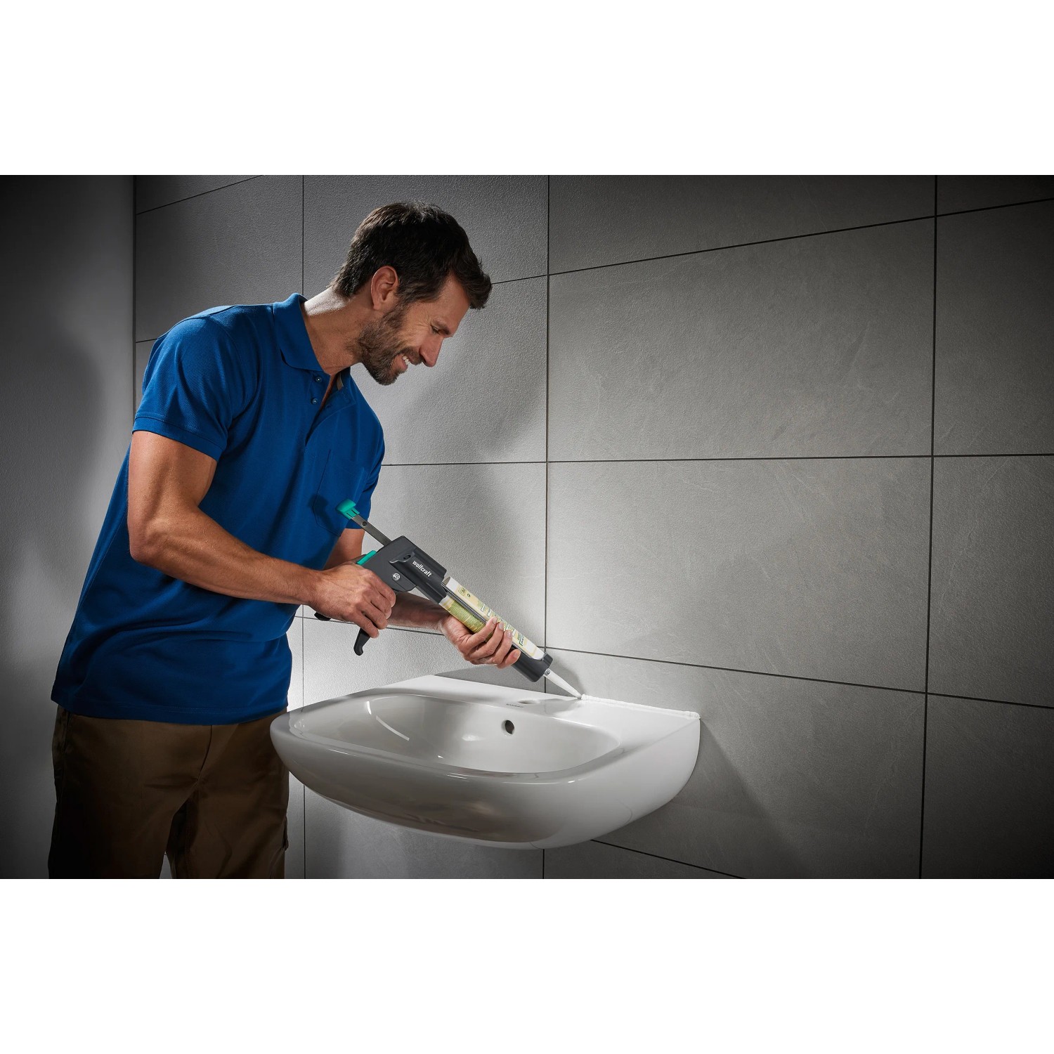 Mann benutzt wolfcraft Kartuschenpresse MG 600 Pro für Silikonarbeiten am Waschbecken.