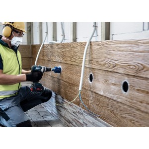Handwerker bohrt Loch mit Bosch Expert Lochsäge Tough Material Ø 20 mm in Holzwand.