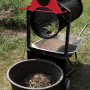 Scheppach Gartenrollsieb RS 400 beim Sieben von Erde in eine Schubkarre und einen Eimer.