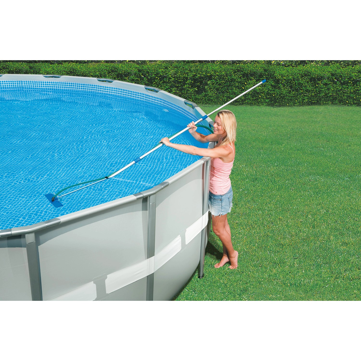 Frau reinigt Pool mit Intex Reinigungs-Set Venturi, Poolsauger mit Teleskopstange.