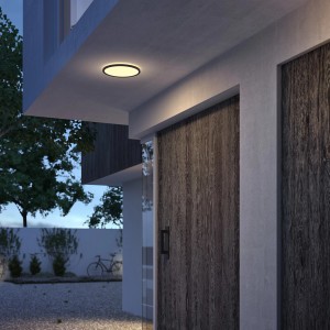 Schwarze Philips SceneSwitch LED-Außendeckenleuchte, 15W, mit warmweißem Licht an Hauswand.