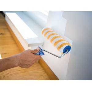 LUX Dispersionswalze 25cm in Aktion: Streichen einer Wand mit gelb-weiß gestreifter Farbwalze.
