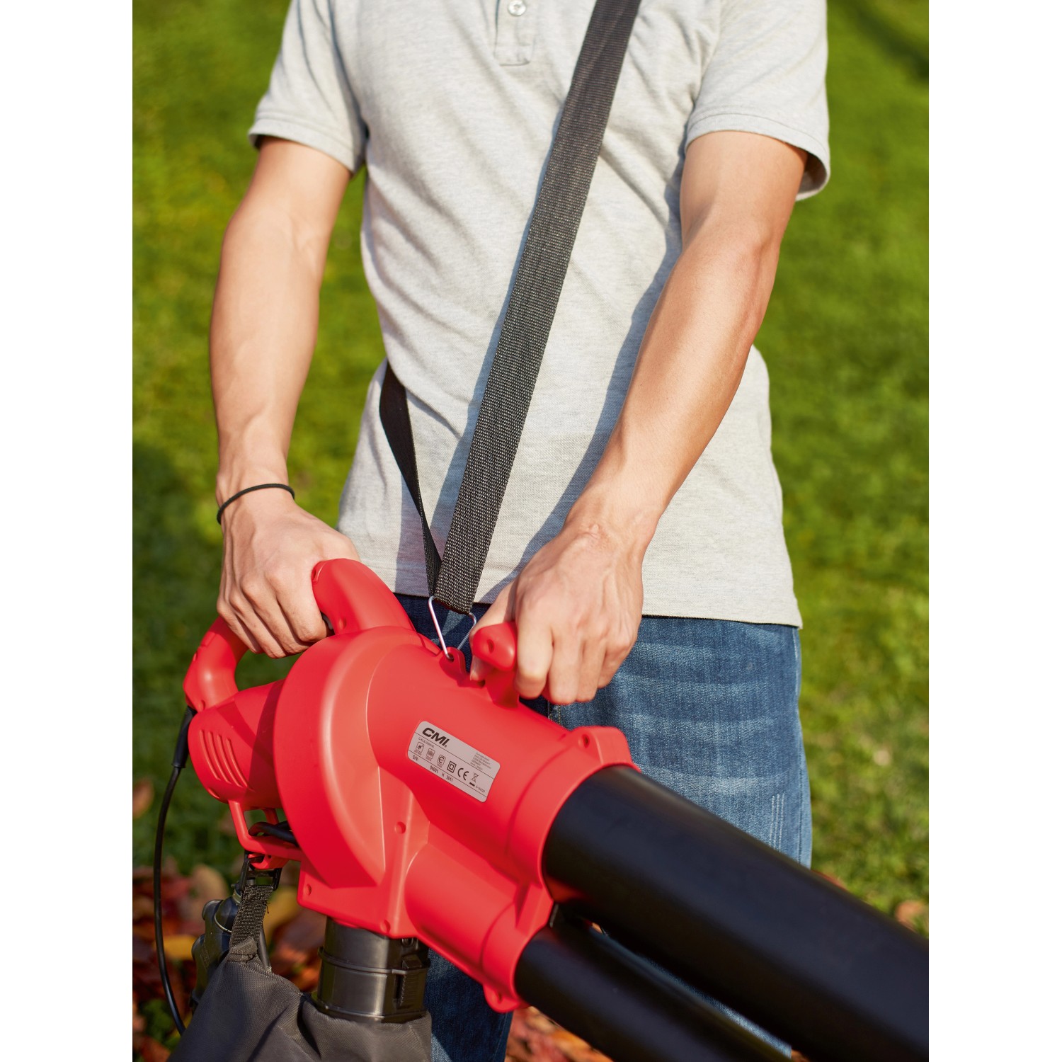 CMI Elektro-Laubsauger 3in1 C-ELS-2500 in Rot mit Tragegurt und Fangsack im Einsatz.