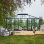 Juliana Gewächshaus Grand Oase 18 Anthrazit mit Sitzbereich im Garten.