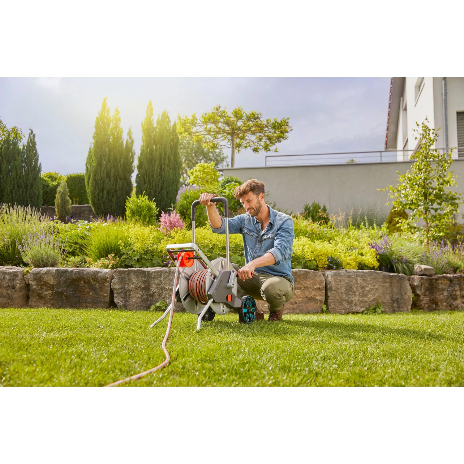 Gardena CleverRoll L Easy Metall Schlauchwagen mit Mann im Garten.