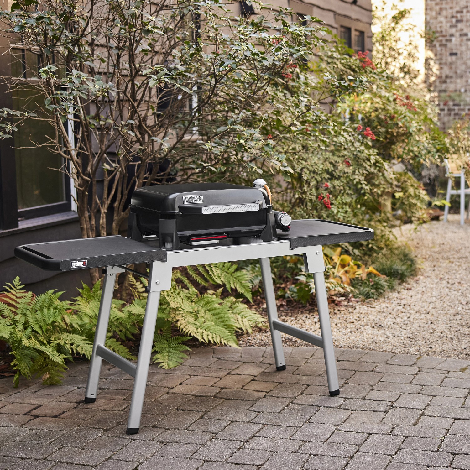 Weber Slate GP 43cm Premium Plancha Gasgrill auf einem Tisch im Garten.
