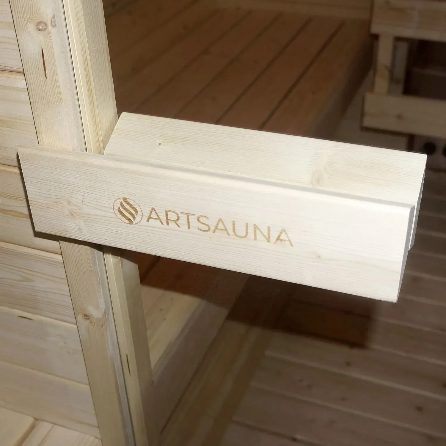 Detailaufnahme Artsauna Cube Fasssauna Nolvik L: Holzbank mit Logo im Inneren der Gartensauna.