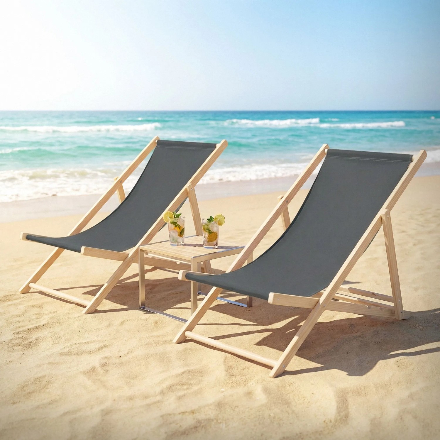 2er Set klappbare ECD Germany Sonnenliegen aus Holz, anthrazitfarben, mit kleinem Tisch am Strand.