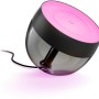 Schwarze Philips Hue Iris Tischleuchte mit farbigem Licht und Kabel.