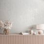 Cremefarbene Marburg Vliestapete in Betonoptik mit Glanzeffekt an einer Wand im Wohnraum.