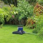 LUX-TOOLS Classic Viereckregner bewässert Rasenfläche im Garten. Regner mit blau-schwarzem Gehäuse.