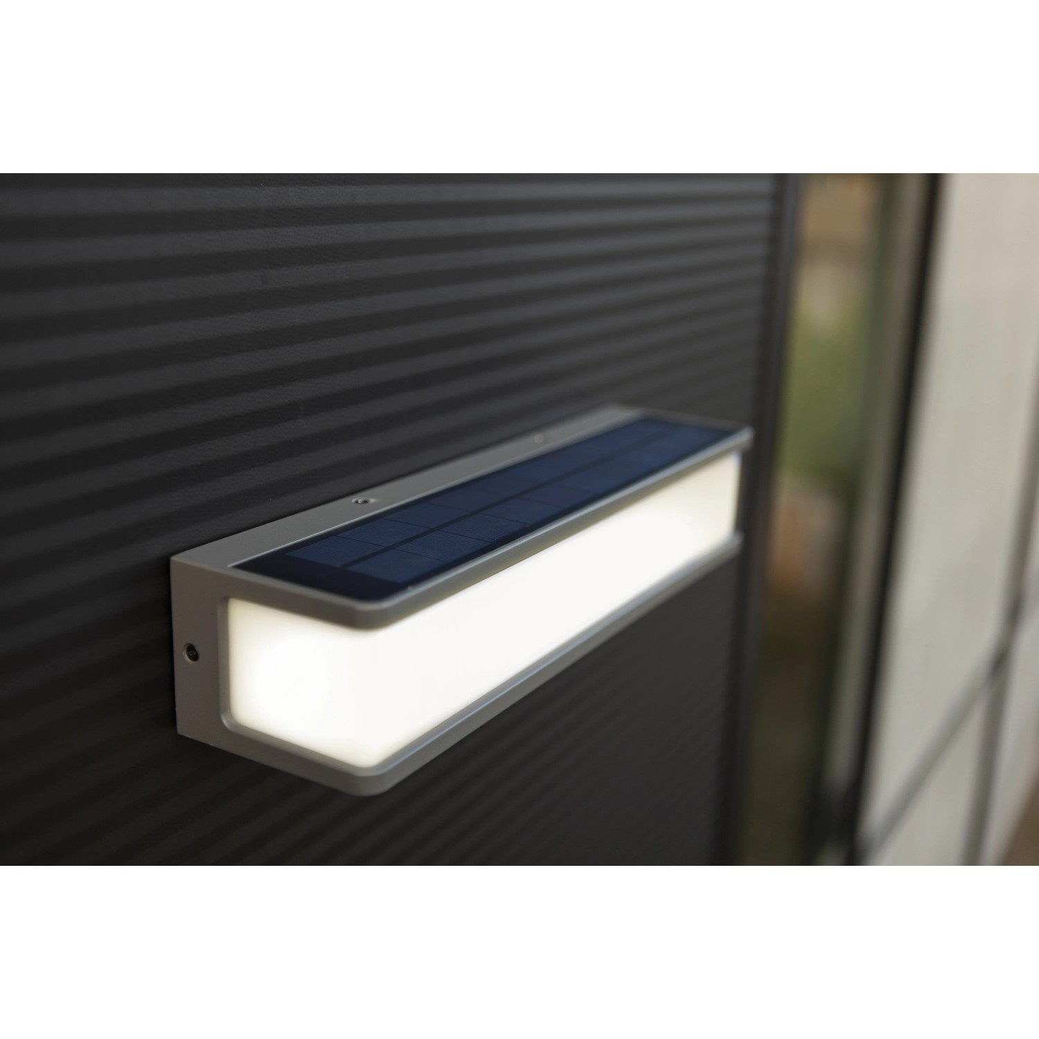 Moderne, anthrazitfarbene Lutec Solar-LED-Wandleuchte Doblo mit Solarpanel. Energiesparende Außenleuchte.