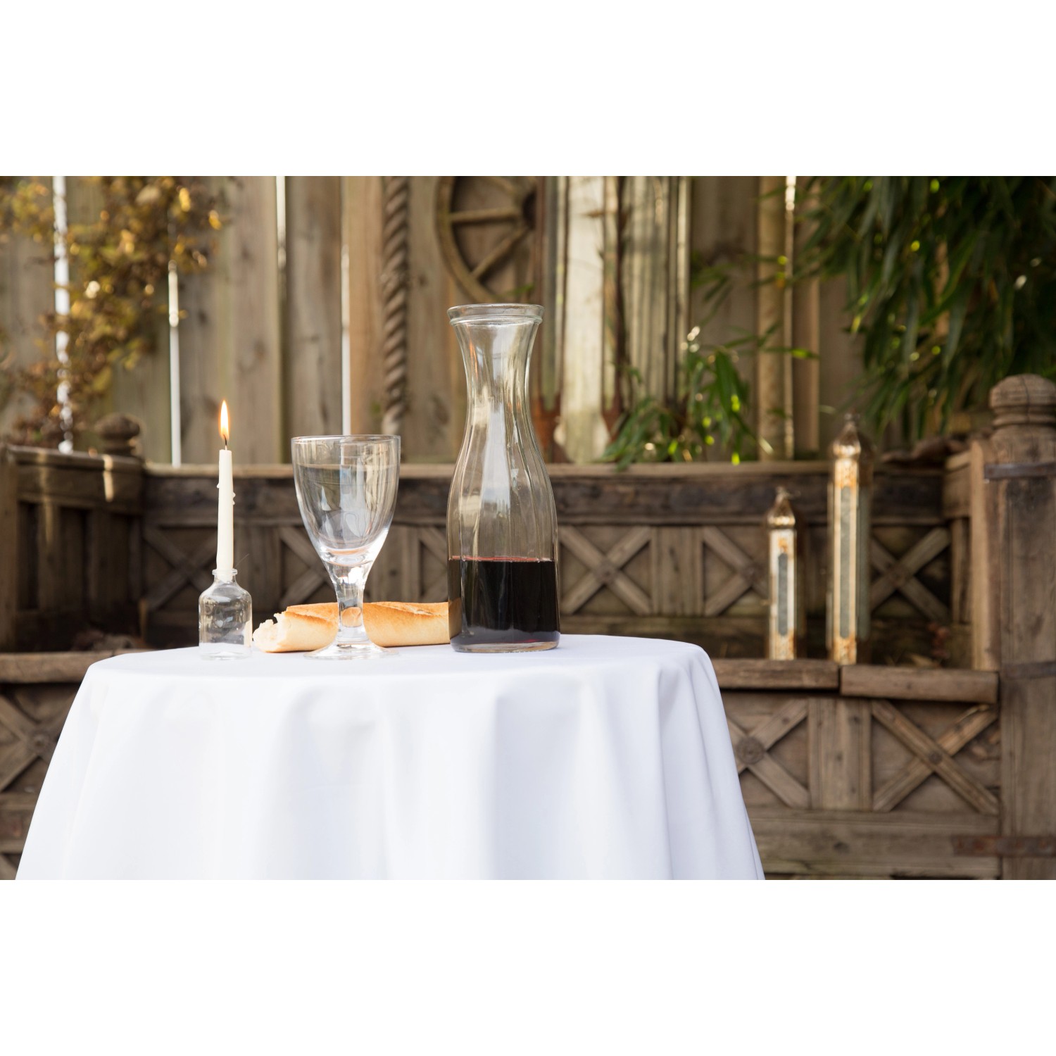 Runde, weiße Floracord Tischdecke (160 cm) auf einem Tisch mit Speisen und Getränken im Freien.