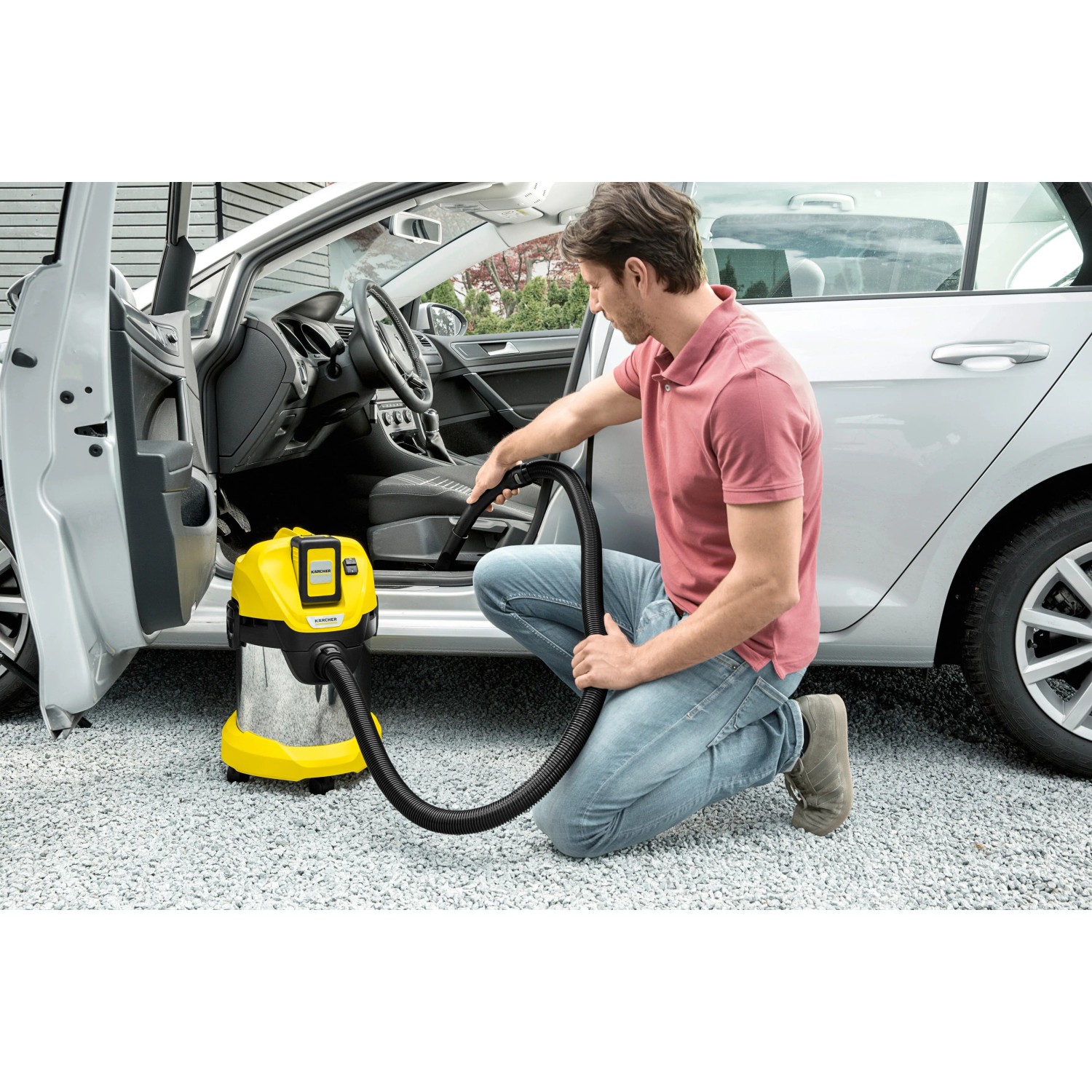 Mann saugt Auto mit gelbem Kärcher Akku-Mehrzwecksauger WD 3 Battery Premium Set.