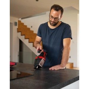 Mann benutzt Einhell Akku-Handstaubsauger TE-HV 18/06 Li-Solo auf einer Küchentheke.