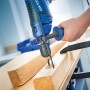 Blaue LUX Schlagbohrmaschine E-BMS-21 mit Tiefenanschlag bohrt in Holz.
