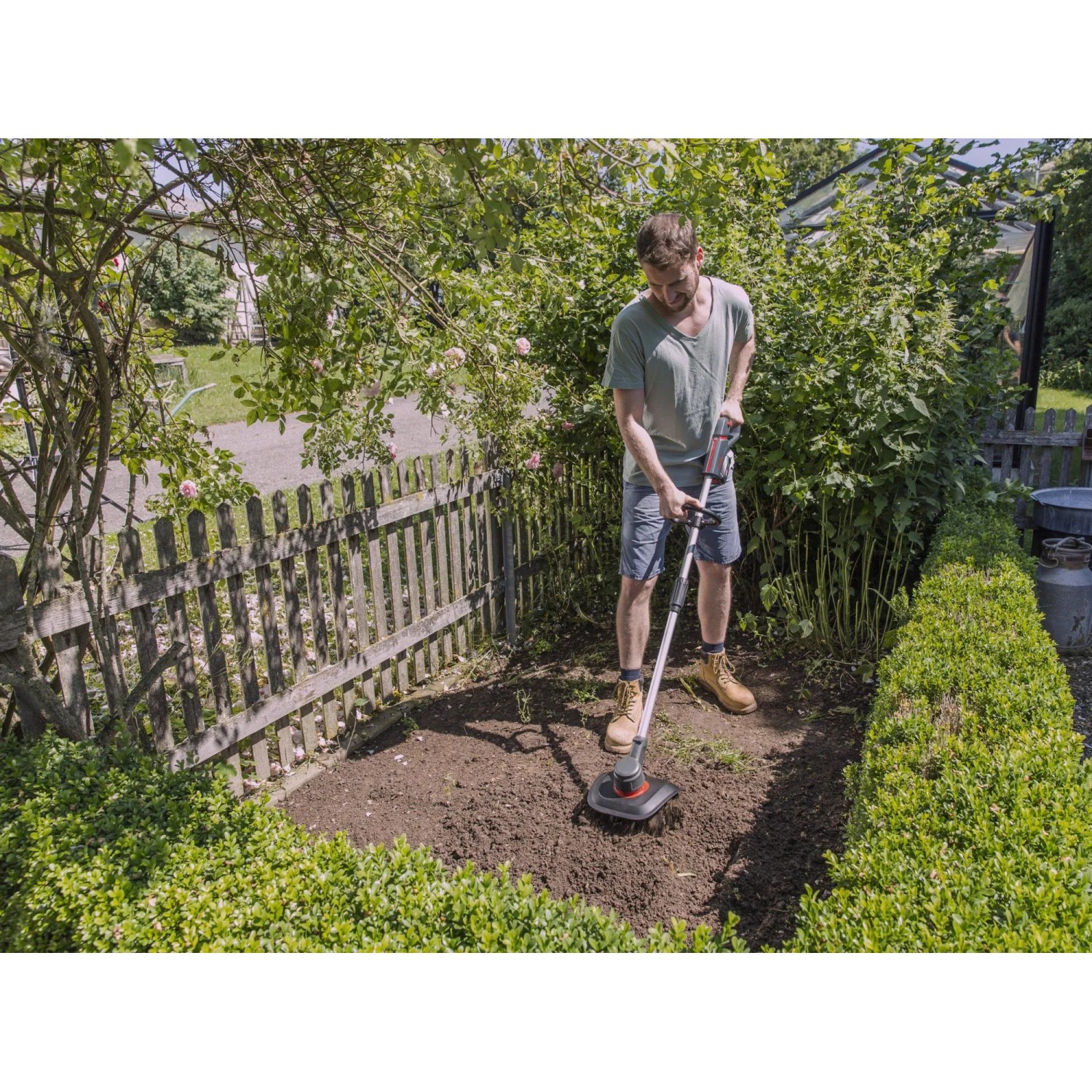 Mann benutzt Al-Ko Akku-Motorhacke TLD 1820 im Garten zur Bodenbearbeitung.