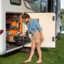 Frau entnimmt Bosch Akkusauger AdvancedVac 18V-8 aus Wohnmobil. Nass- & Trockensauger mit Zubehör.