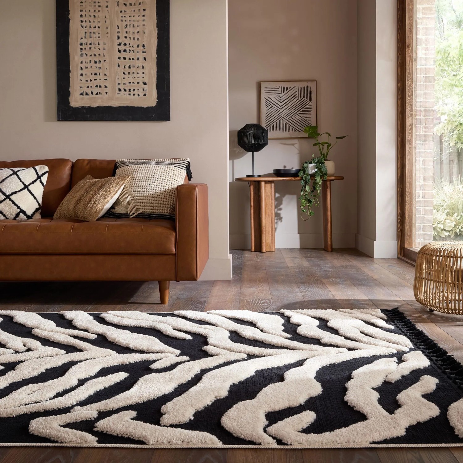 Schwarz-weißer Hochflorteppich Esra Zebra mit zotteligem Flor im Wohnzimmer. Weicher Polyester Teppich.