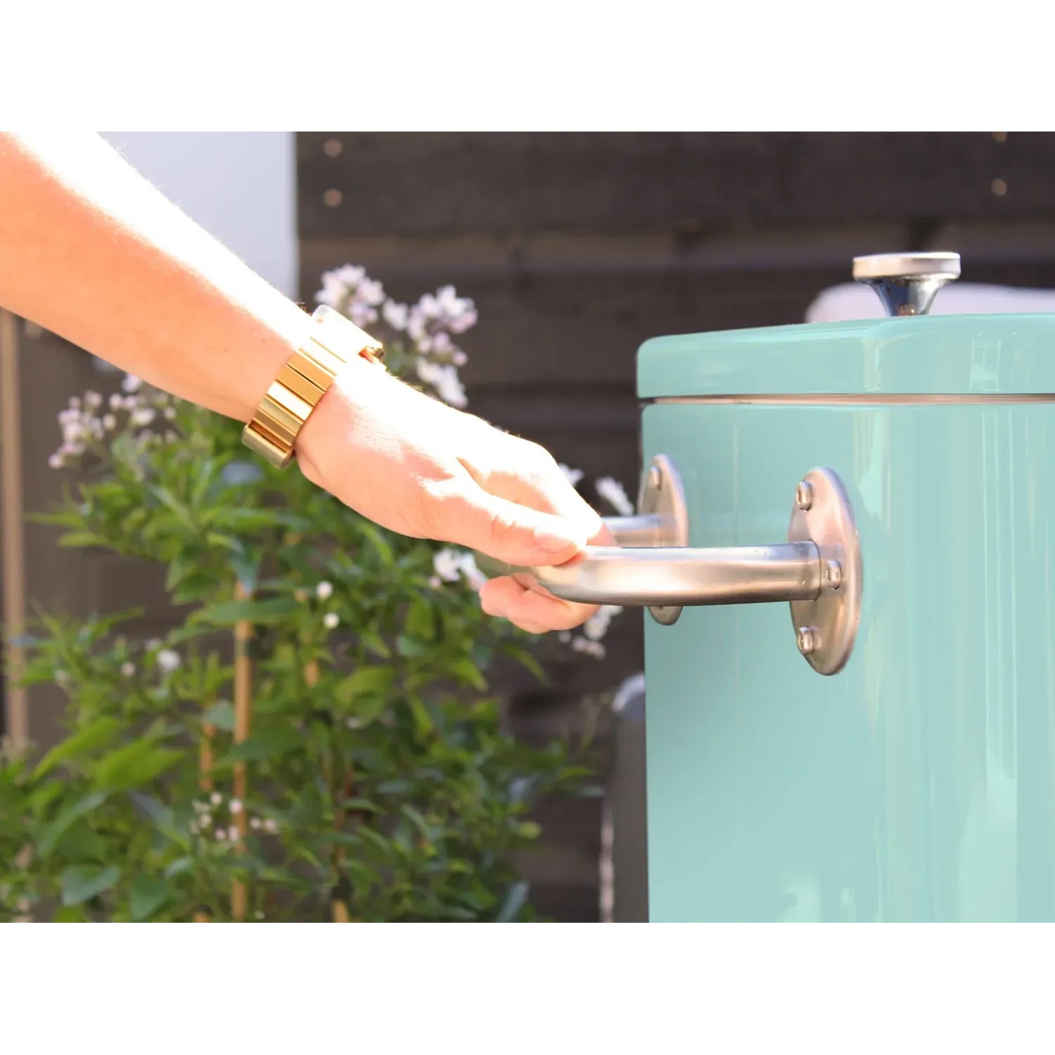 Axi Kühlwagen Retro Mint 76l: Hand öffnet mintgrüne Kühlbox mit Griff im Retro-Design.