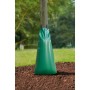 Grüner Baumbewässerungssack (100 l) am Baumstamm im Garten.