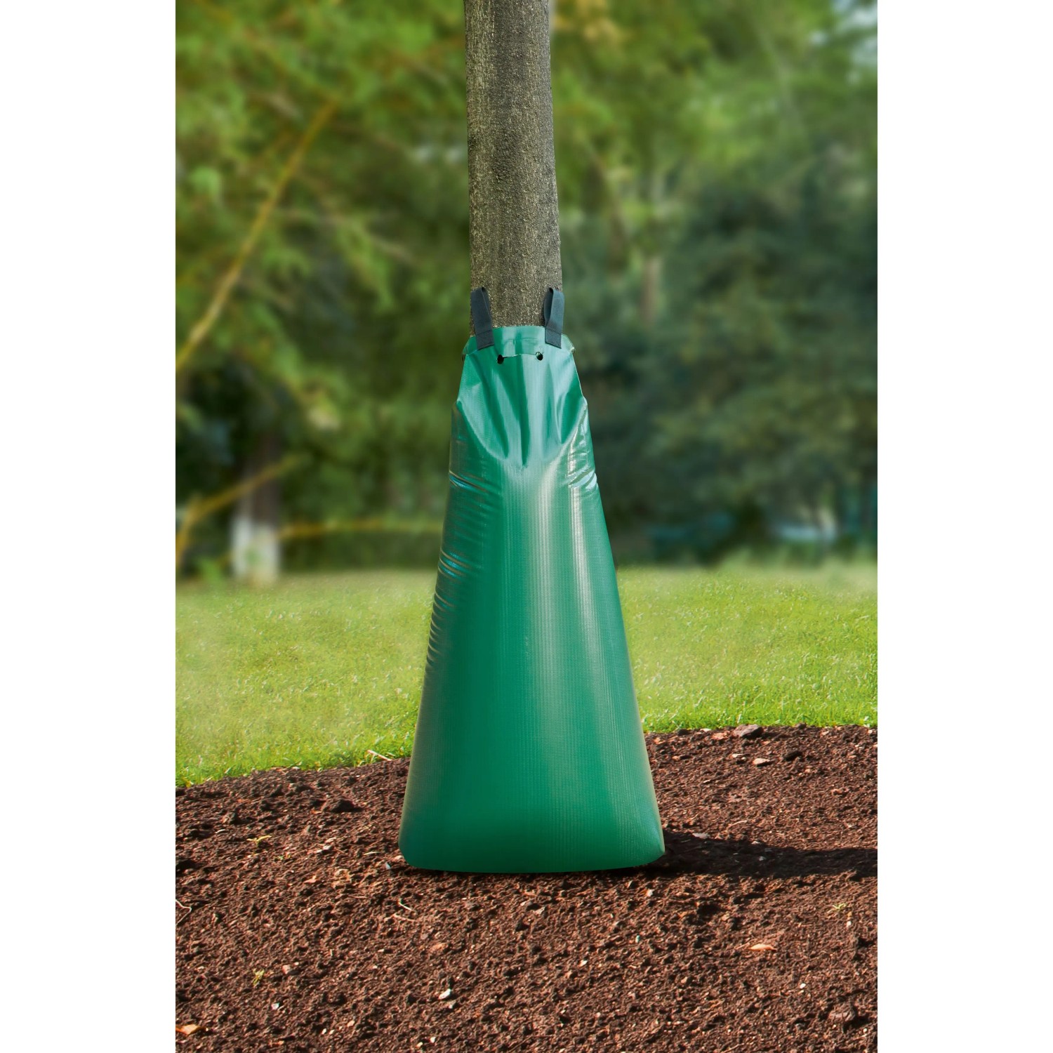 Grüner Baumbewässerungssack (100 l) am Baumstamm im Garten.