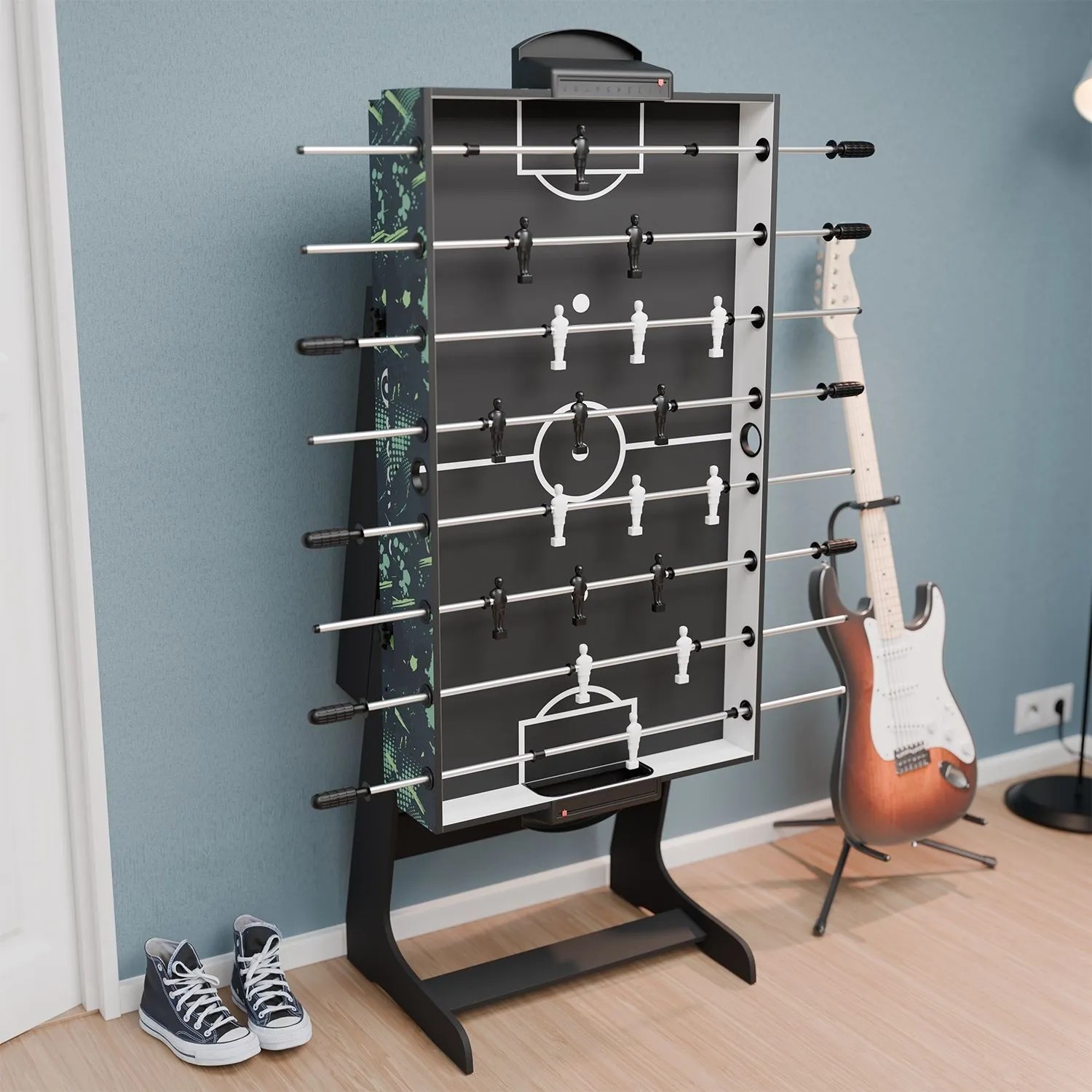 Juskys 5in1 Multi-Spieltisch Ballzauber als Tischkicker mit Gitarre und Schuhen im Hintergrund.
