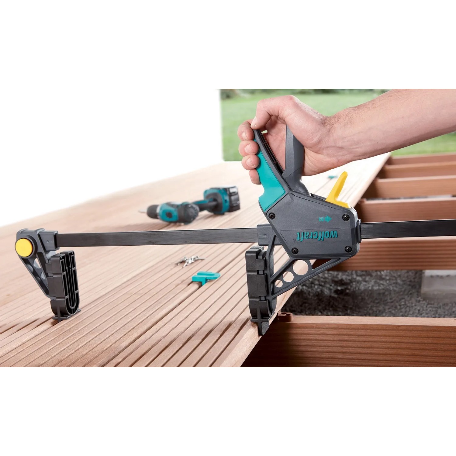 Wolfcraft Terrassenbau Set im Einsatz: Montagezwinge fixiert Terrassendielen.