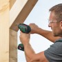 Mann schraubt mit Bosch 18V Akku-Bohrschrauber Advanced Drill 18 V-80 Solo eine Schraube in ein Holzbrett.