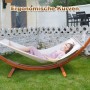 Beige HOMAVO Hängematte mit Holzgestell, Maße 320x120x120 cm. Frau liegt entspannt in der Hängematte.