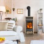 Fireplace Santiago Kaminofen 6 kW in Sandstein-Optik, stehend im Wohnzimmer.