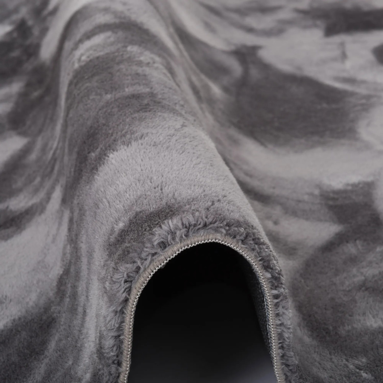 Detailaufnahme: Weicher, anthrazitfarbener Fellteppich Pergamon Luxus Super Soft mit Marmormuster.