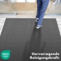 Anthrazitfarbene KARAT Schmutzfangmatte SKY Novo (120x180 cm) vor Eingangstür mit Person.