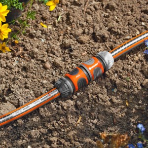 Gardena Kupplung zum Verbinden von zwei Gartenschläuchen im Beet.