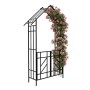 Schwarzer Eisen-Rosenbogen mit Spitzdach und Tor, bewachsen mit rosa Kletterrosen. Ideal als Rankhilfe im Garten.