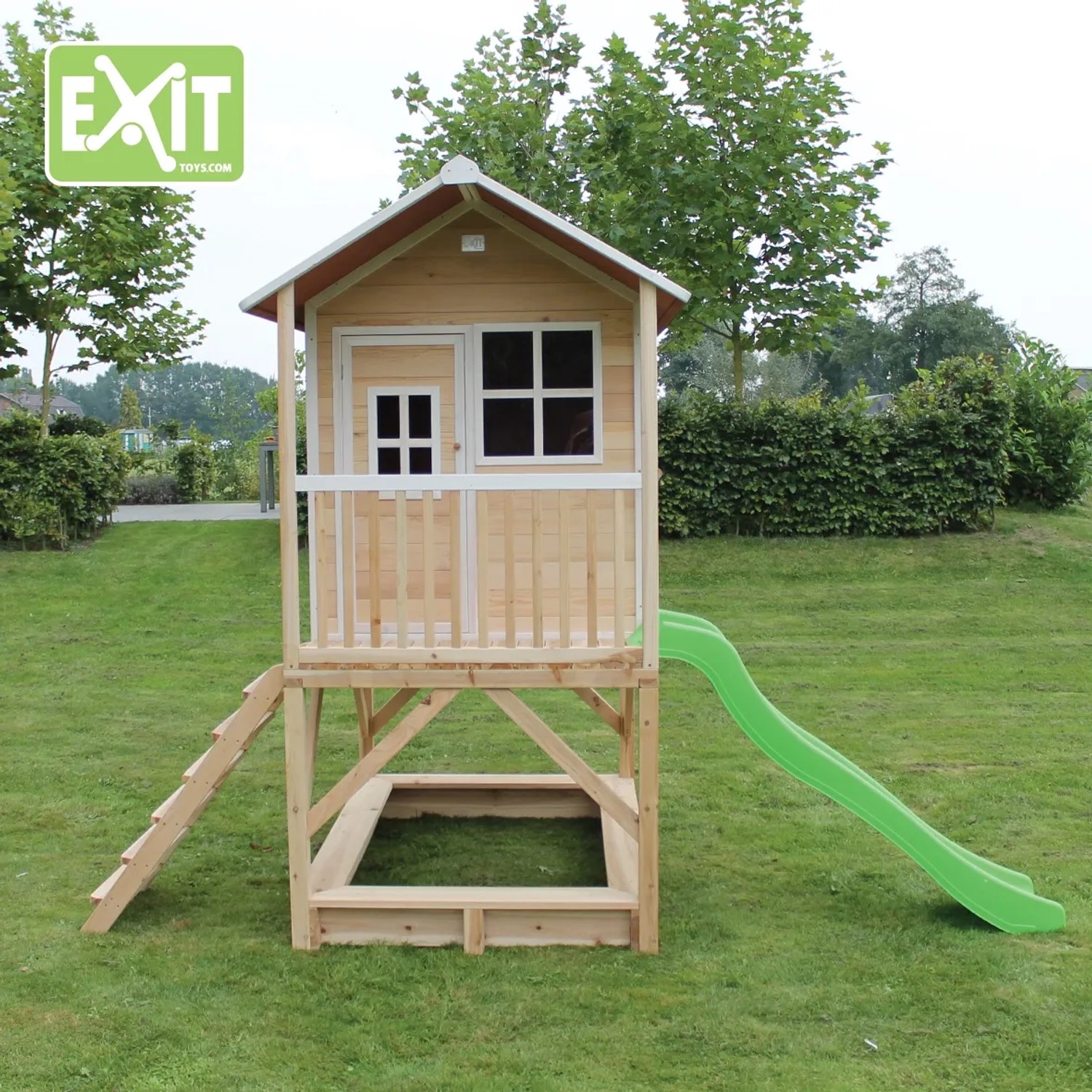 EXIT Loft 500 Holzspielhaus naturel mit Rutsche, Sandkasten und Leiter im Garten.