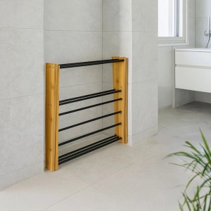 Klappbarer Wäscheständer aus hellem Holz mit schwarzen Metallstangen in gefliestem Raum. Platzsparendes Design.