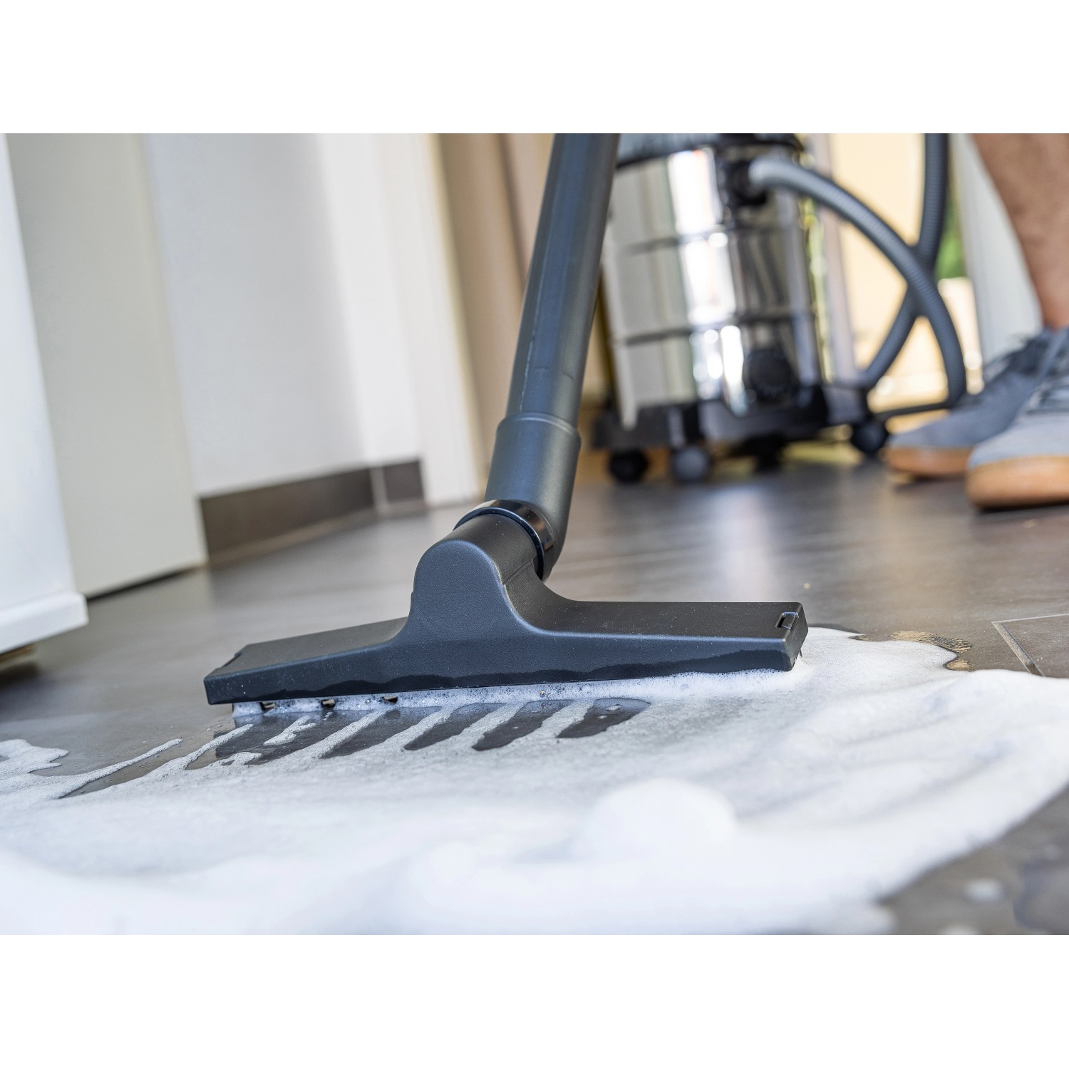 Teichschlammsauger 2.0 Edelstahl im Einsatz, reinigt mit Bürste und Saugschlauch einen Boden mit Wasser.