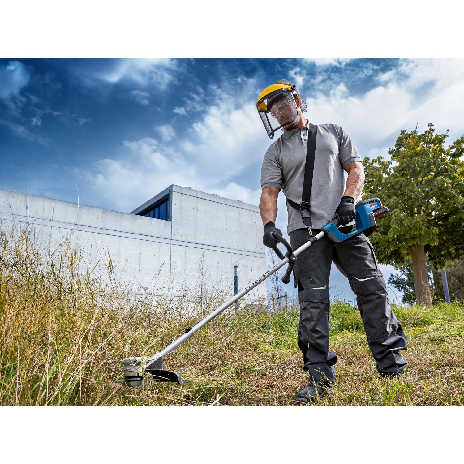 Mann mit Bosch Akku-Freischneider GFR 18V-23 beim Trimmen von Gras.