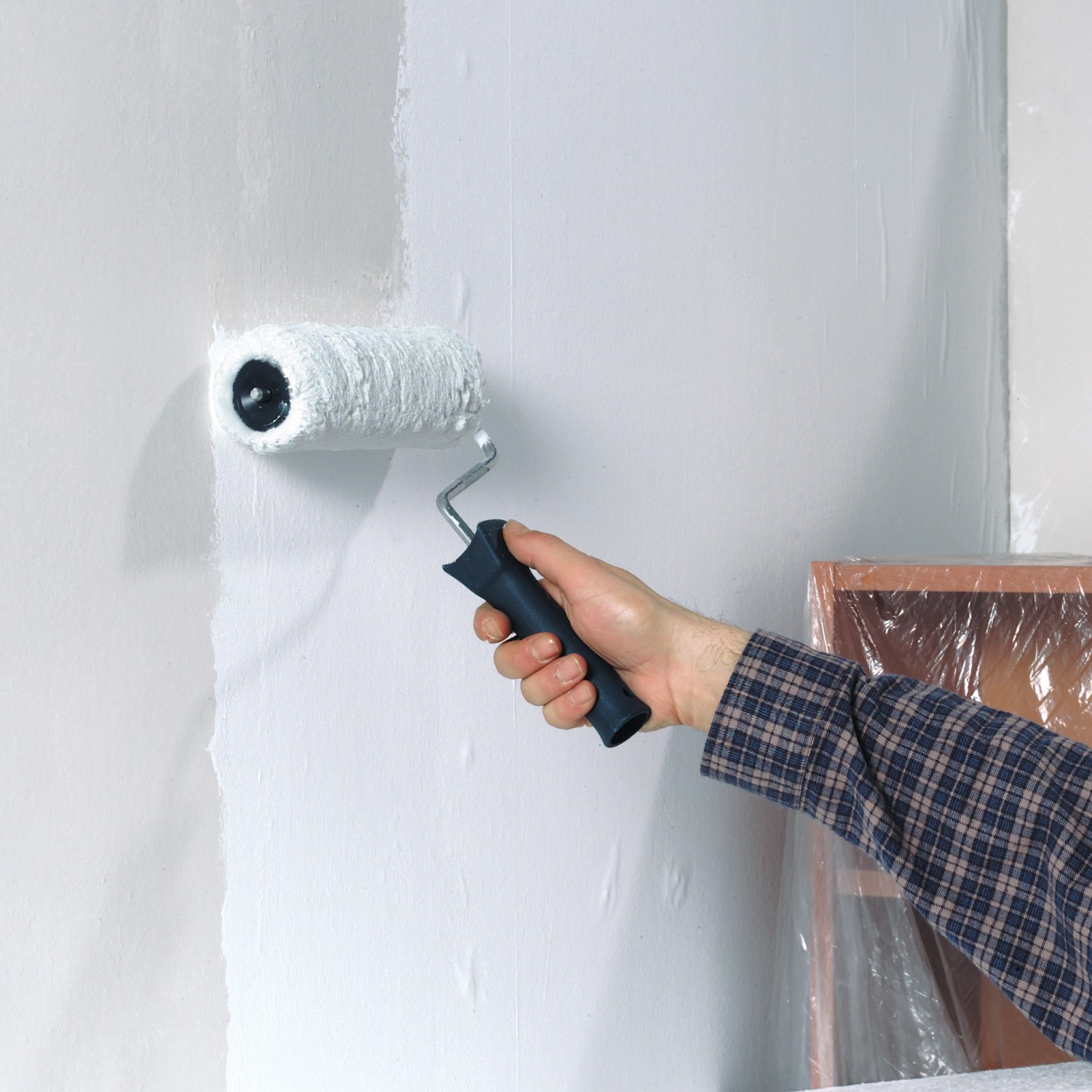 Hand streicht Wand mit LUX Vestanwalze 18 cm. Farbwalze für Dispersionsfarbe.
