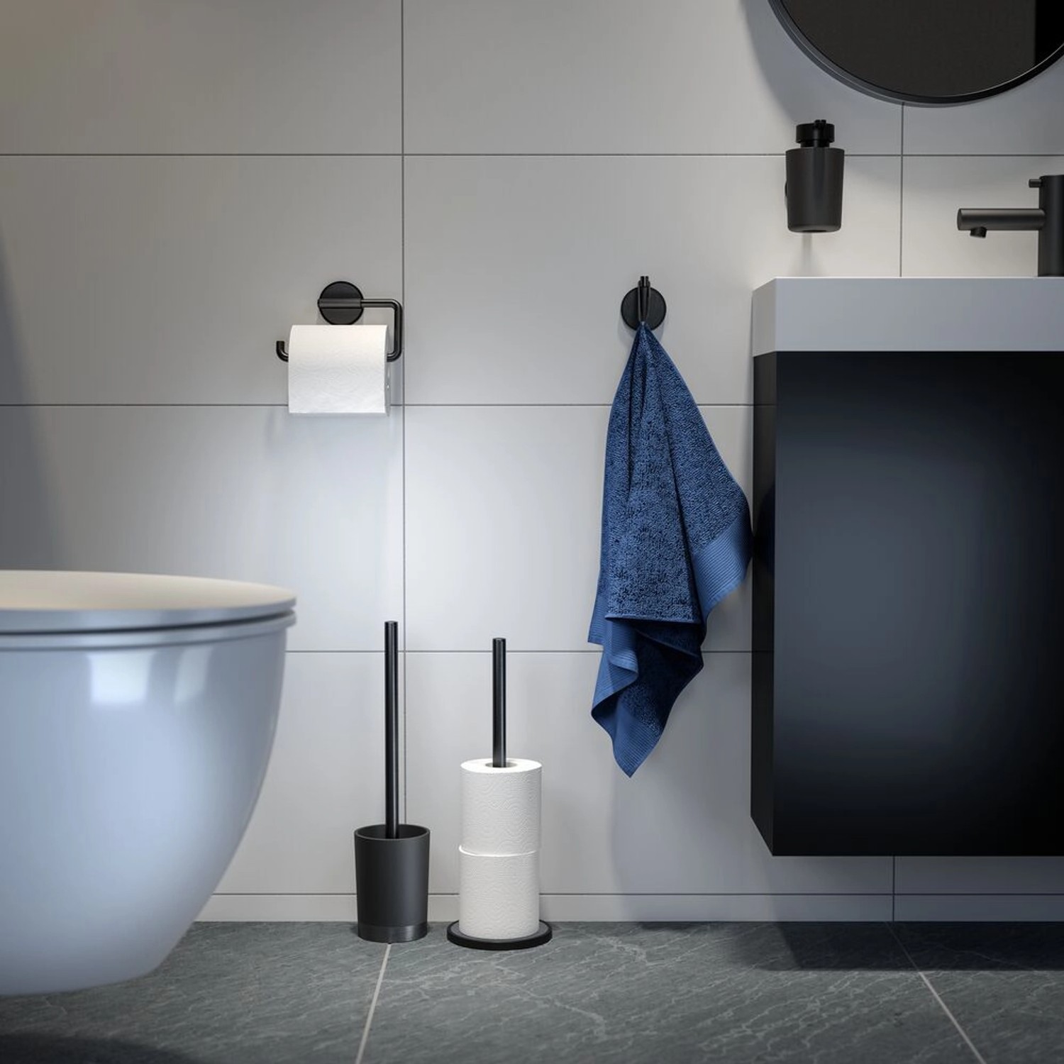 Badezimmer-Szene mit Tiger Seifenspender Tune, Toilettenpapierhalter und WC-Garnitur in Schwarz gebürstet.