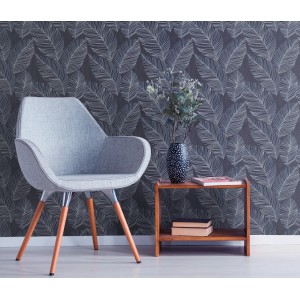 Erismann Vliestapete Paradisio 2 mit blauem Blattmotiv im Raum, kombiniert mit Sessel und Tisch.