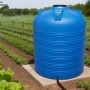 Blauer KMND 5000L Trinkwasser Wassertank aus PE auf Betonplatte im Garten, zur Bewässerung von Pflanzen.