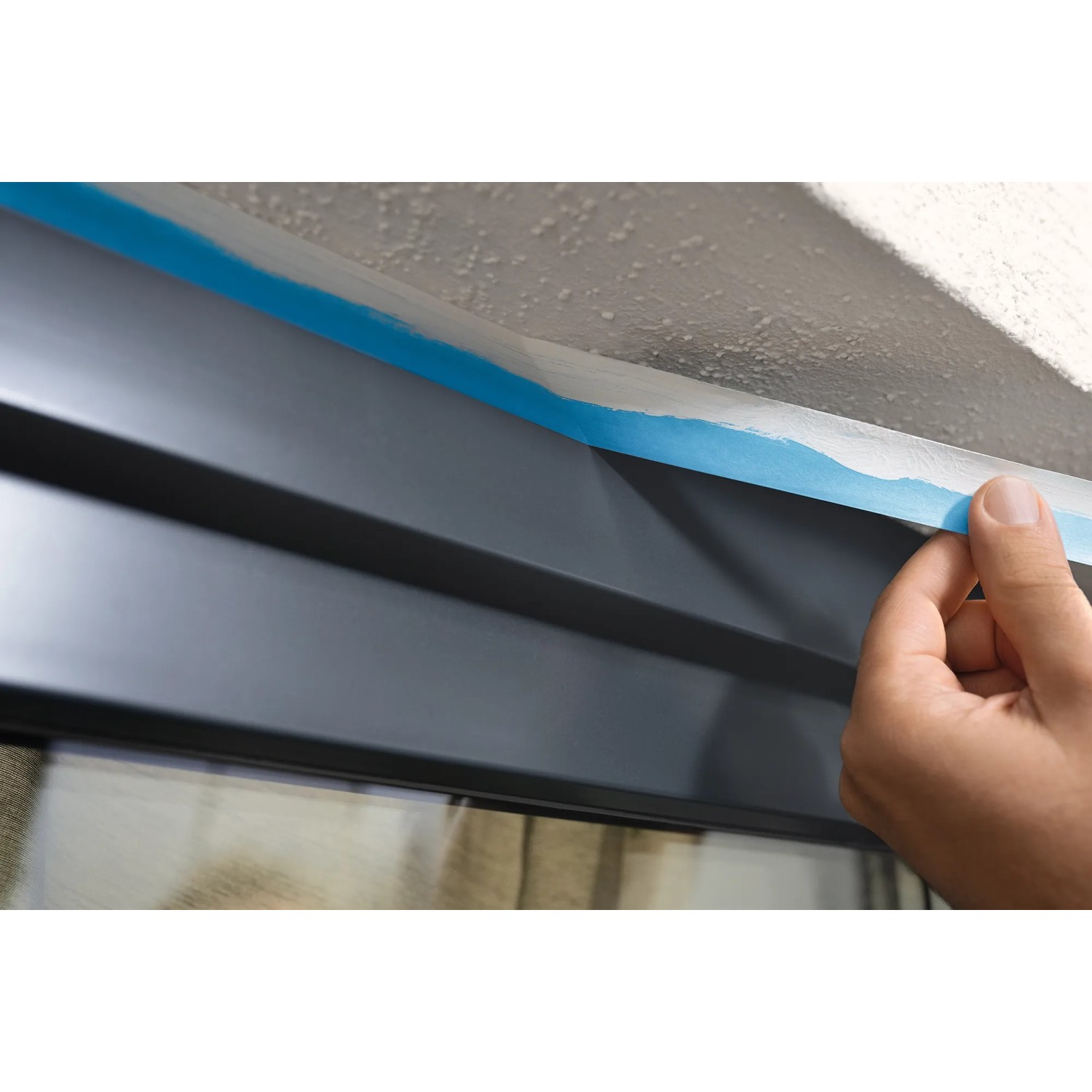 Anwendung von Tesa Malerband Professional Outdoor (25mm) zum Abkleben im Außenbereich.