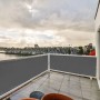 Grauer Balkon Sichtschutz aus Polyesterfaser, blickdicht, an weißem Geländer montiert. Ideal für Privatsphäre.